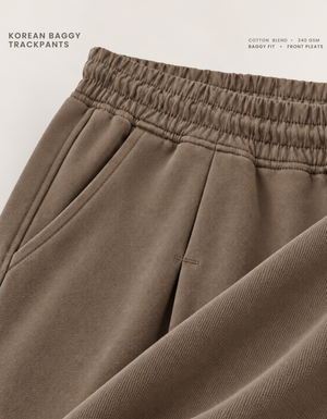 Front pleat stitching and side pocket detail on brown Korean baggy pants, 340 GSM cotton blend